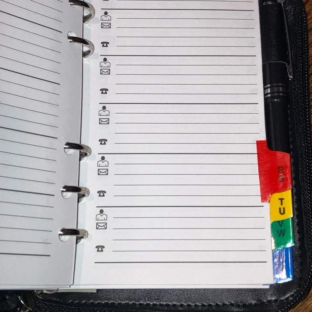 Black planner/organizer with zippered closure, wallet slot, addresses, goals